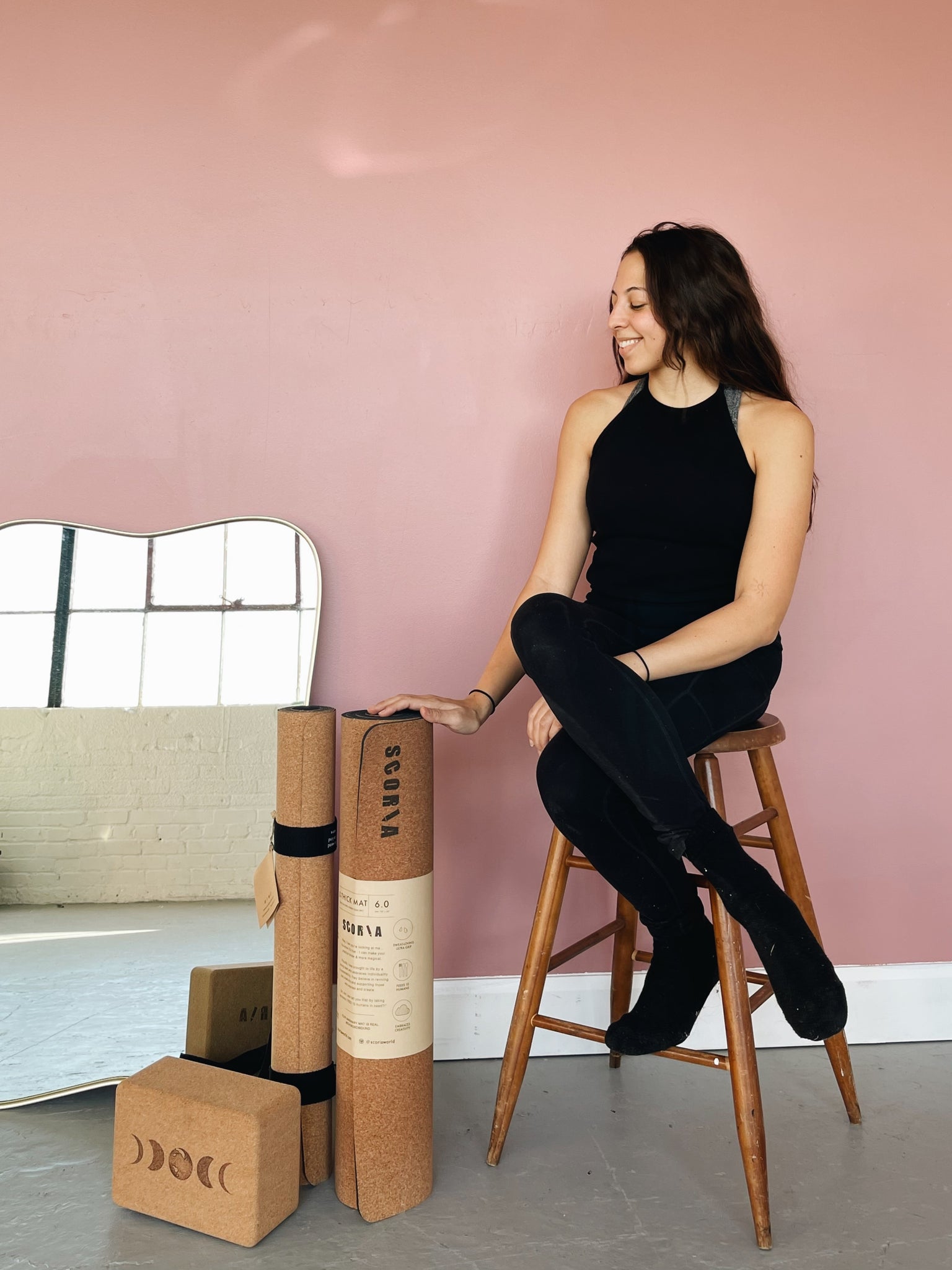 Yara Kamal sitting with Scoria cork yoga mats and cork Moon Phase block